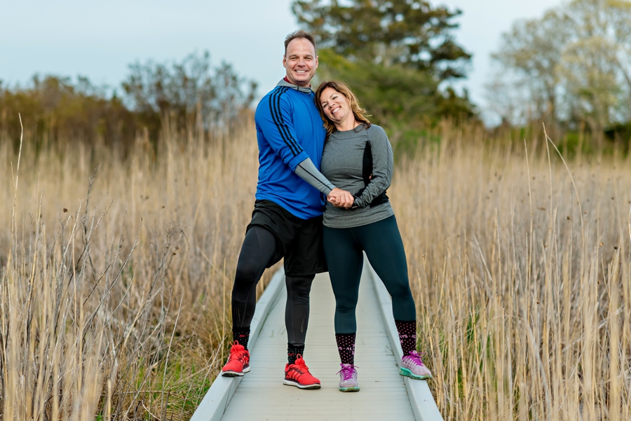 An engaged couple hold hands after a bike ride on the beach in cape may, nj.